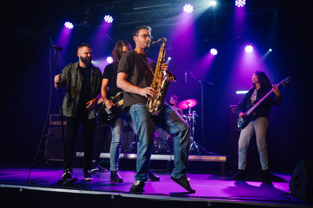 istock Music band playing live on stage during a concert, saxophone player in foreground 2185015692