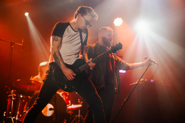 istock Guitarist performing with band on stage during concert 2185015758