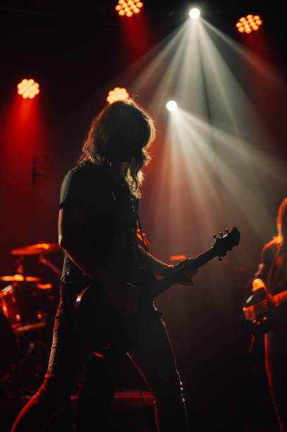 istock Guitarist performing live on stage under red lights 2185015767