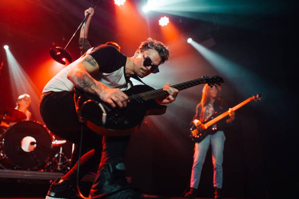 istock Guitarist performing live on stage with band 2185015776