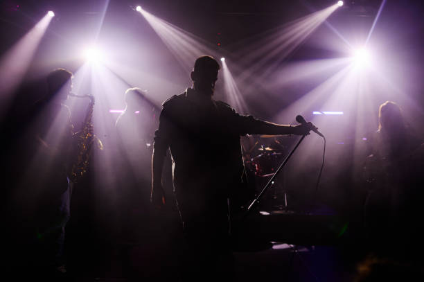 istock Singer performing with band on stage under purple lights 2185015778