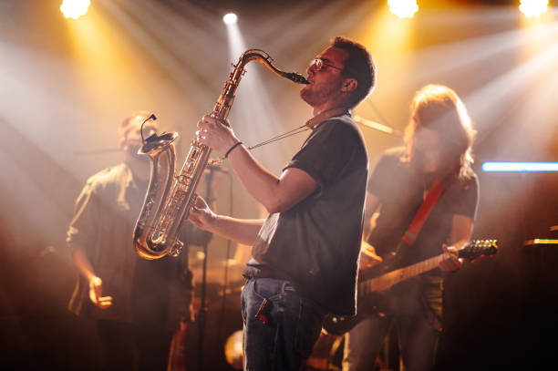 istock Saxophonist playing sax on stage with band during concert 2185015781