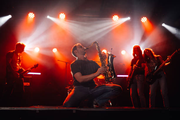 istock Saxophonist performing live with band on stage with red lighting 2185015785