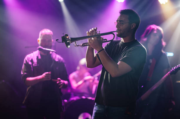 istock Trumpet player performing live on stage with band in purple light 2185015788