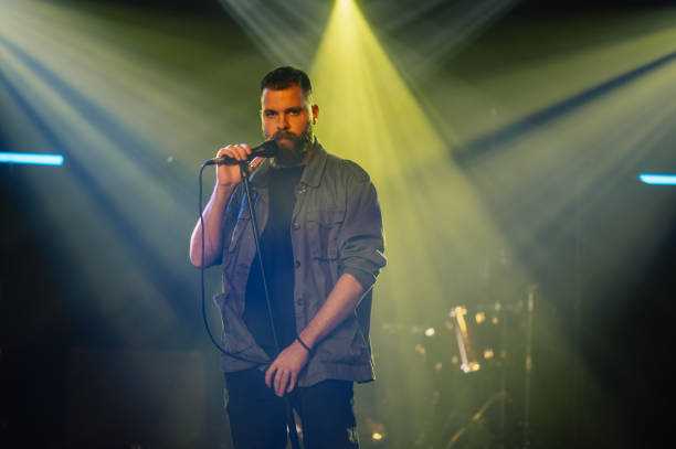 istock Singer performing live on stage with microphone and stage lights 2185015790