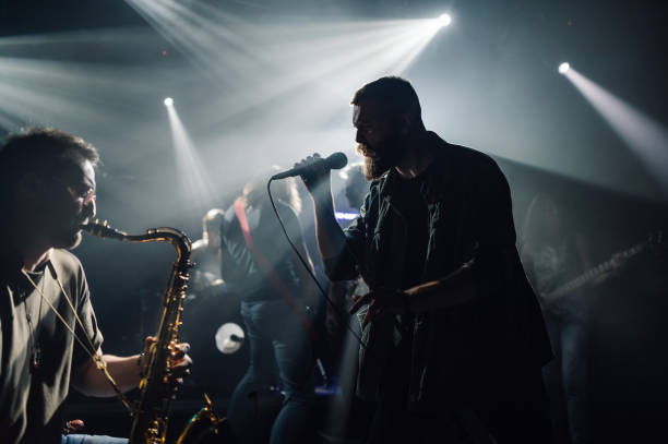 istock Musicians playing live music during a concert under stage lights 2185015792