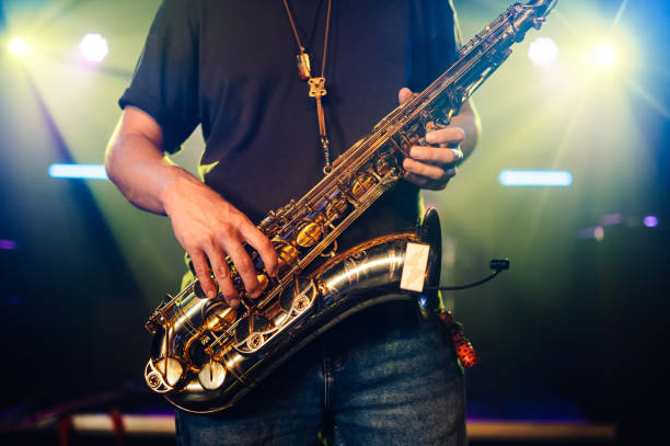 istock Saxophonist performing live on stage with bright lights 2185015810