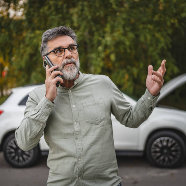 istock worried senior man stand behind open hood make a phone call for help 2185018293