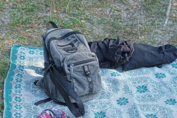 istock one grey full backpack and black crumpled clothes lie on a blanket 2185019515