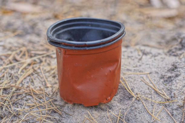 istock one old crumpled plastic brown black small flowerpot 2185019564