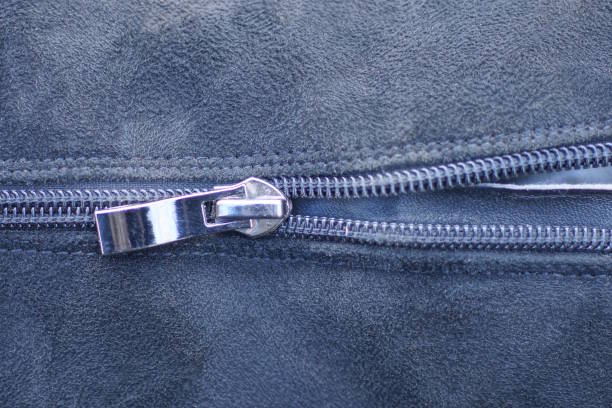 part of black suede boot with closed gray plastic metal zip