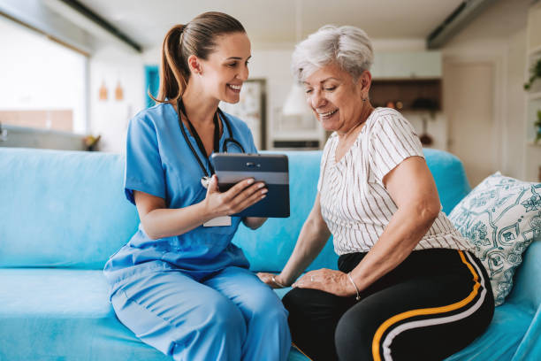 istock Home care healthcare professional using digital tablet 2185020337