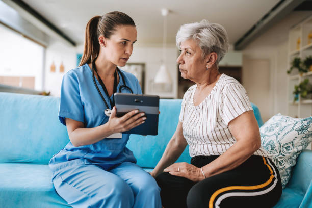 istock Home care healthcare professional using digital tablet 2185020339