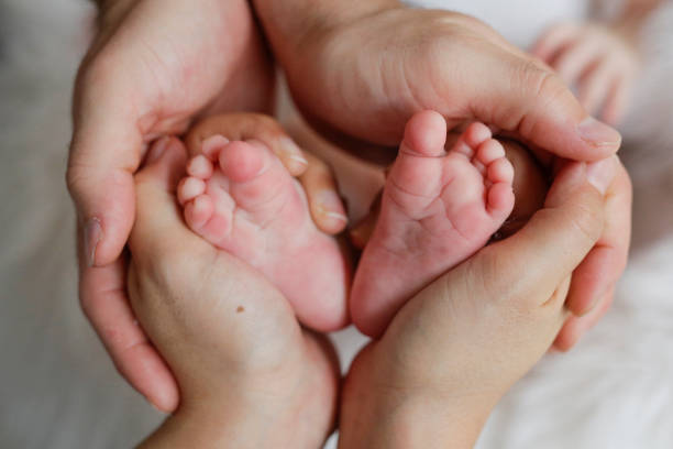 istock Happy Home: A Precious Little Foot Surrounded by Parental Love 2185021812