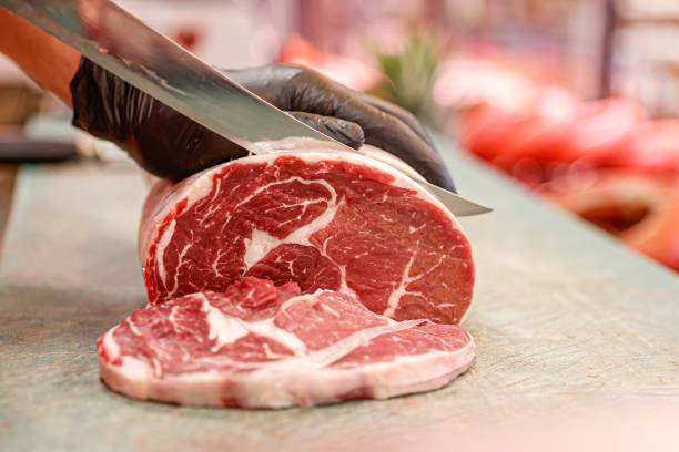 istock Skilled Hands: Butcher Cutting Fresh Raw Meat with Precision 2185021873