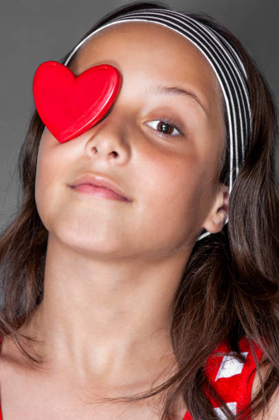 A cute child's hands form a heart shape, symbolizing love and kindness. The concepts of healthcare, charity, organ donation, generosity, pleasure, hope, love, and World Heart Day.