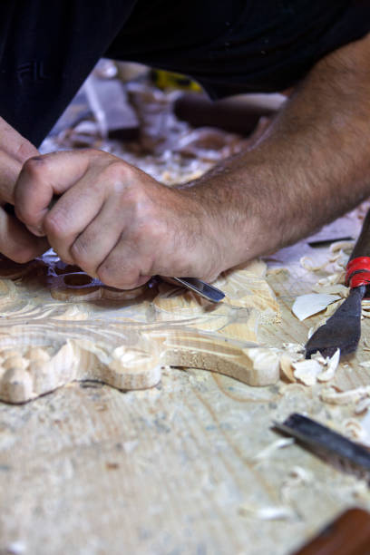istock man with a chisel sculpting wood in the workshop 2185024005