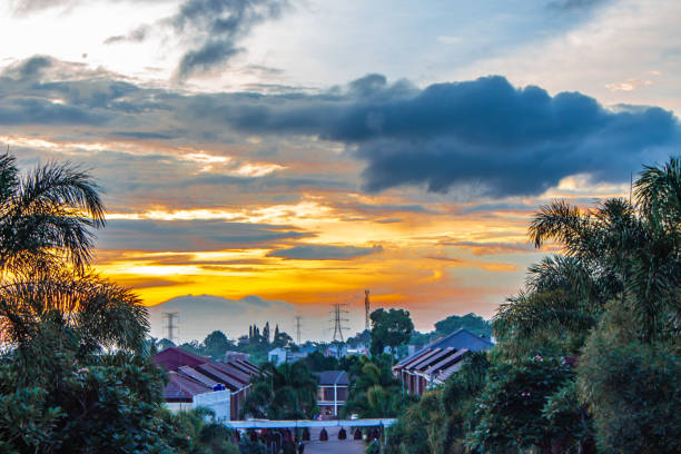 High power pole, silhouette , Sunset, the city. Vivid sunset behind over the small city