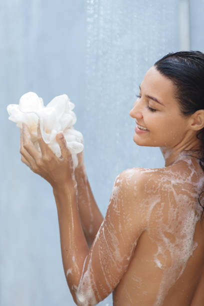 istock Smiling Woman Enjoying Shower While Lathering Loofah 2185036722