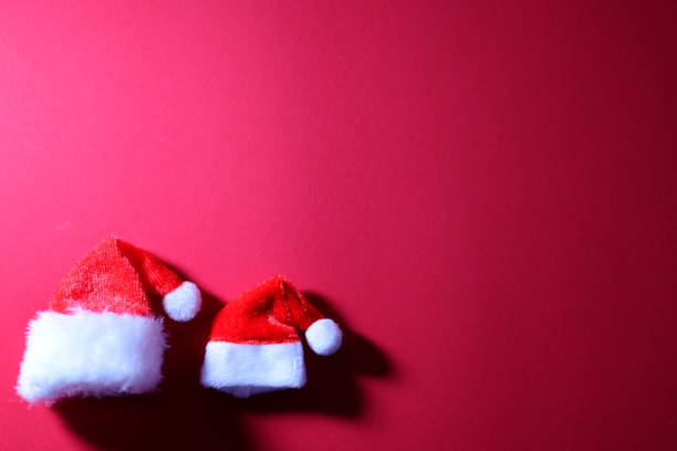 istock Santa Claus hats on red background. 2185040086