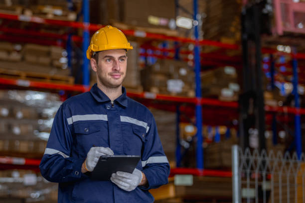 istock Man paper warehouse worker holding tablet checking inspecting quality cardboard corrugated carton in storage. Large industry in paper product line manufacturing. 2185047888