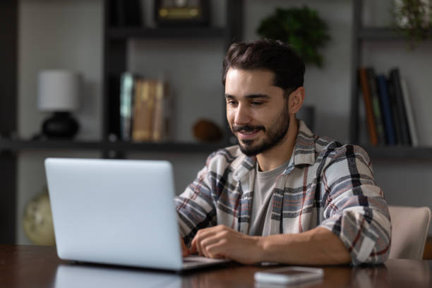 istock Handsome young man working with laptop in home office 2185049223