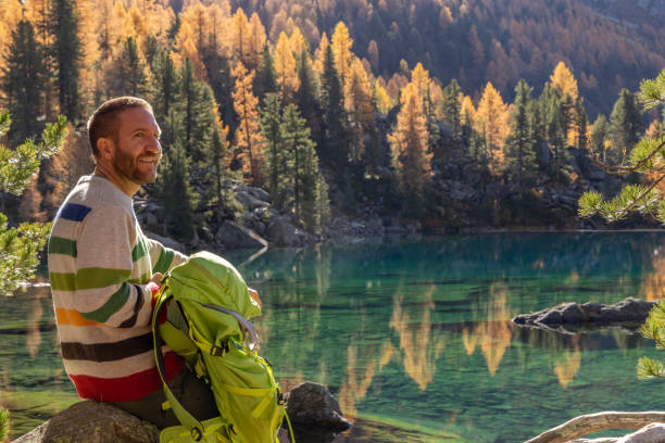 istock A man hiking by a pristine alpine lake in autumn 2185054478