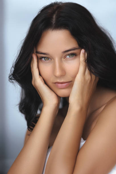 istock Serene Woman Wrapped In Blanket Resting Face In Hands With Soft Glow 2185055847
