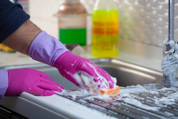 cleaning kitchen cabinets with sponge and spray