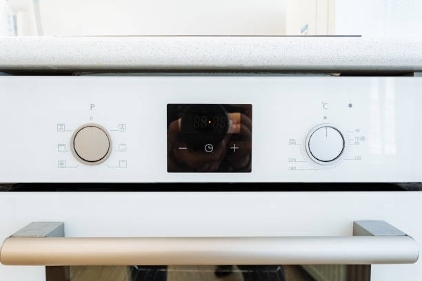 istock Modern white kitchen oven with digital display and stainless steel handles is a sleek addition to contemporary kitchens. Convenient, efficient, and perfect for cooking and baking 2185068823