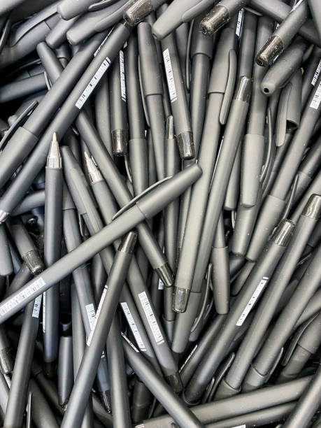 A sizable stack of black pens can be seen, each with a sleek design and smooth finish, perfect for writing or artistic endeavors, showcasing an array of patterns or styles