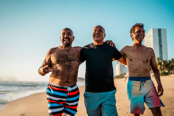 istock Senior friends men walking on the beach 2185081239