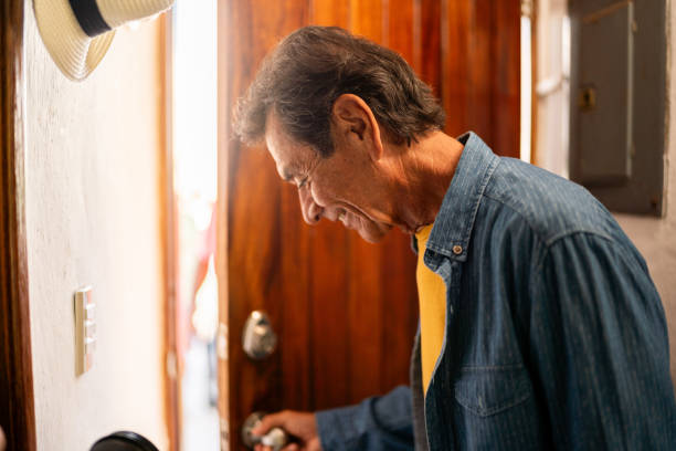 istock Senior man opening door at home 2185082856