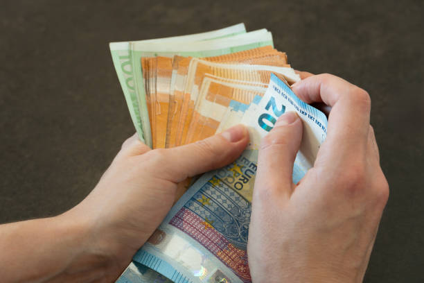 istock Close-up of woman's hands counting euro banknotes 2185085571