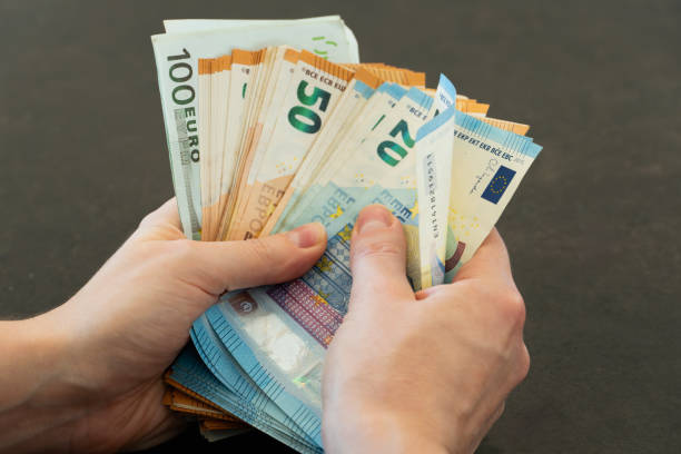istock Close-up of woman's hands counting euro banknotes 2185085572