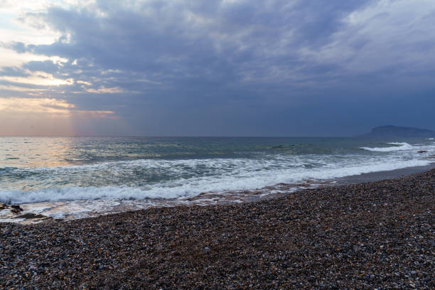 istock Serene Pebble Beach at Sunset with Radiant Sky and Ocean Waves 2185088041