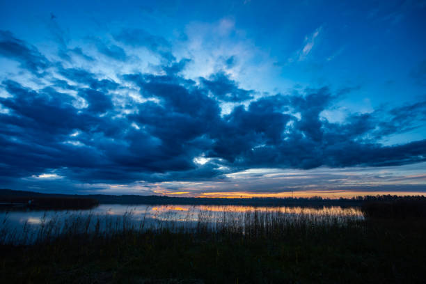 A stunning twilight scene with clouds reflecting on a calm lake, perfect for tranquil visuals and art