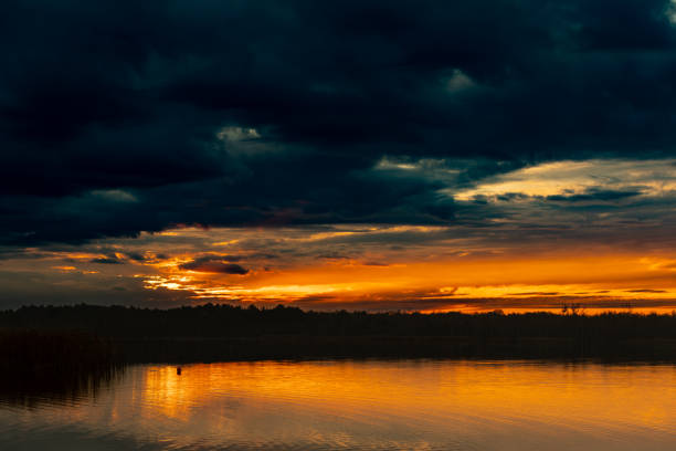 istock A Dramatic and Colorful Sunset Over Calm Water with Stunning Reflections and Clouds 2185096621