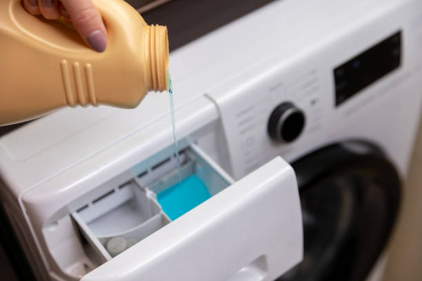 istock Pouring Liquid Detergent into the Washing Machine Drawer for a Fresh Laundry Cycle 2185097202