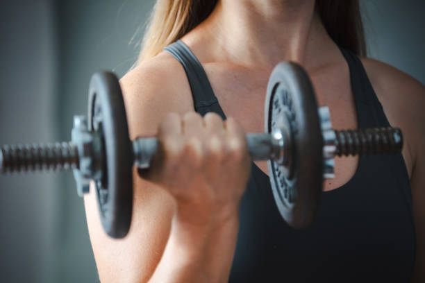 istock Sporty woman is training with dumbbell. 2185105952