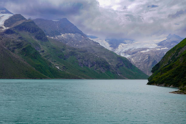 Kaprun high mountain reservoirs - dramatic environment in summer. Mountain peak in the dark stormy clouds. August 20, 2024.