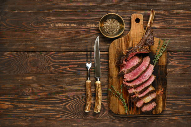 istock A perfectly cooked tomahawk steak served on a wooden cutting board with herbs and utensils 2185107979