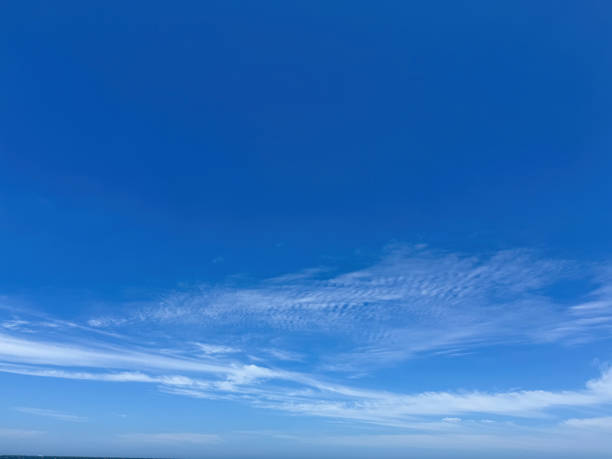 istock Clear blue sky with light, white clouds background. Expansive blue sky and  thin scattered clouds 2185109066