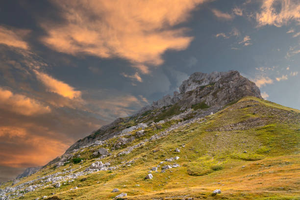 Bright high peak of mountain rock against blue sky.