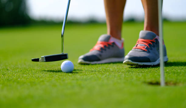 istock Golf player preparing to putt on the green at a sunny golf course 2185113223