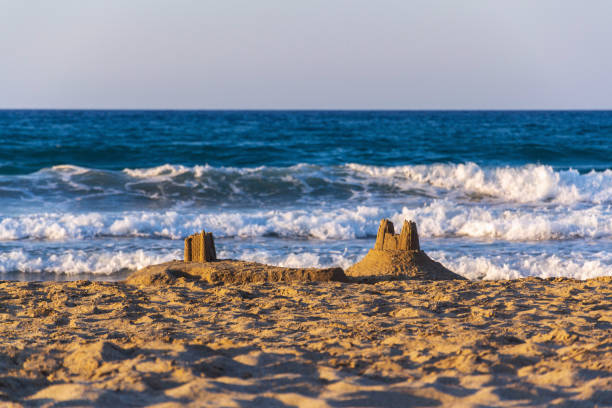 Beautiful sand castle on the beach at sunset, childrens creativity, active vacation concept