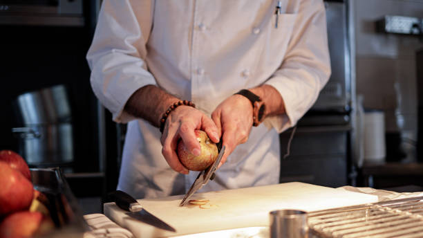 istock Chef slicing fresh apple in a professional kitchen, preparing ingredients with precision for a culinary dish 2185115273