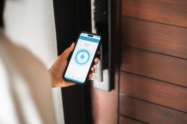 Smart Lock Access Controlled by Mobile App Close-up of a hand using a smartphone app to control a smart lock, demonstrating modern home security technology. Suitable for concepts of IoT, convenience, and digital safety. door chain stock pictures, royalty-free photos & images