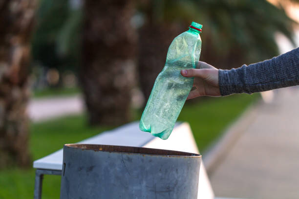 istock Person throws a plastic bottle in the trash. Waste separation 2185119882