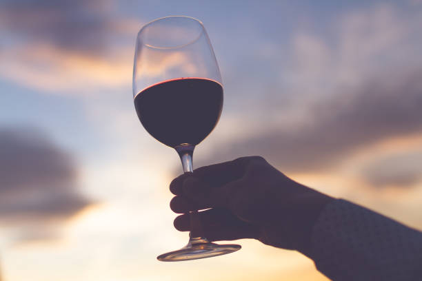 istock A glass wine in hand at sunset in the evening 2185121999